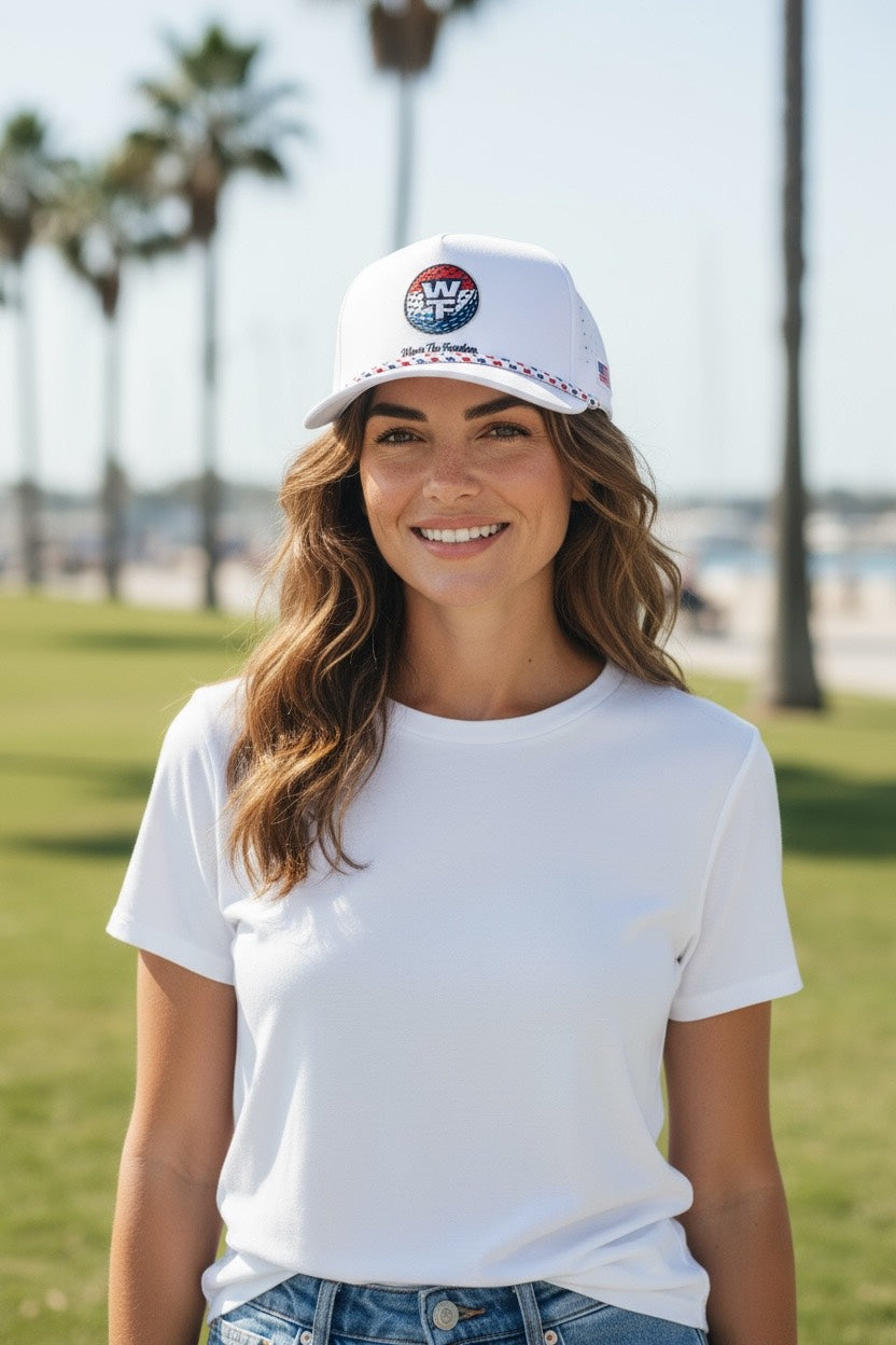 Woman wearing a white t-shirt and a cap with palm trees in the background